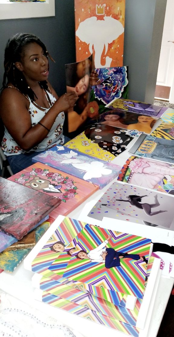 Nika B displaying her original artwork for sale at a vendor event