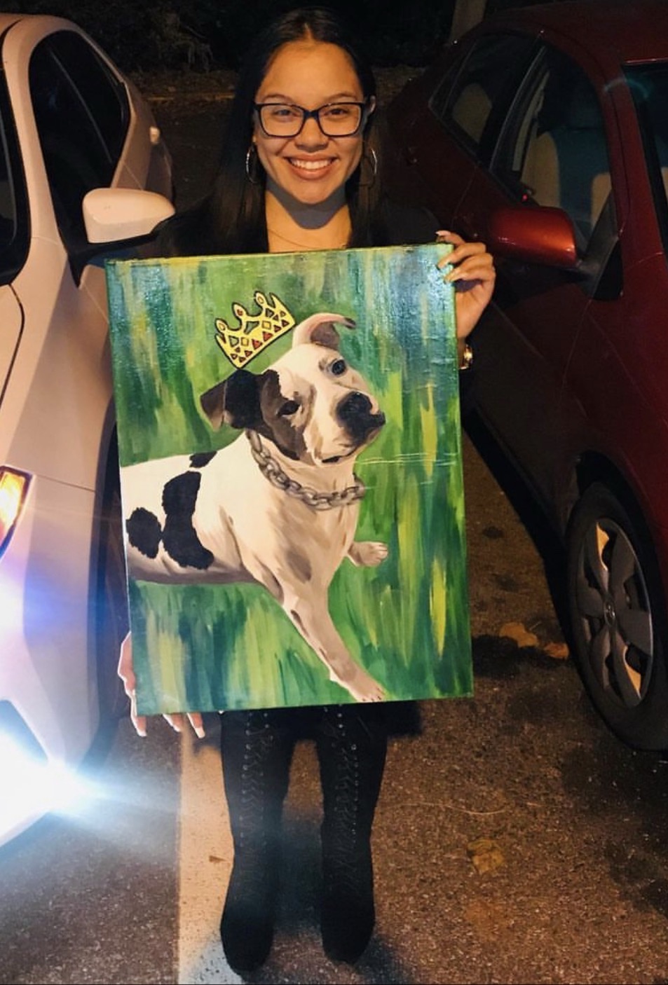 Collector holding her commissioned portrait of a crowned dog