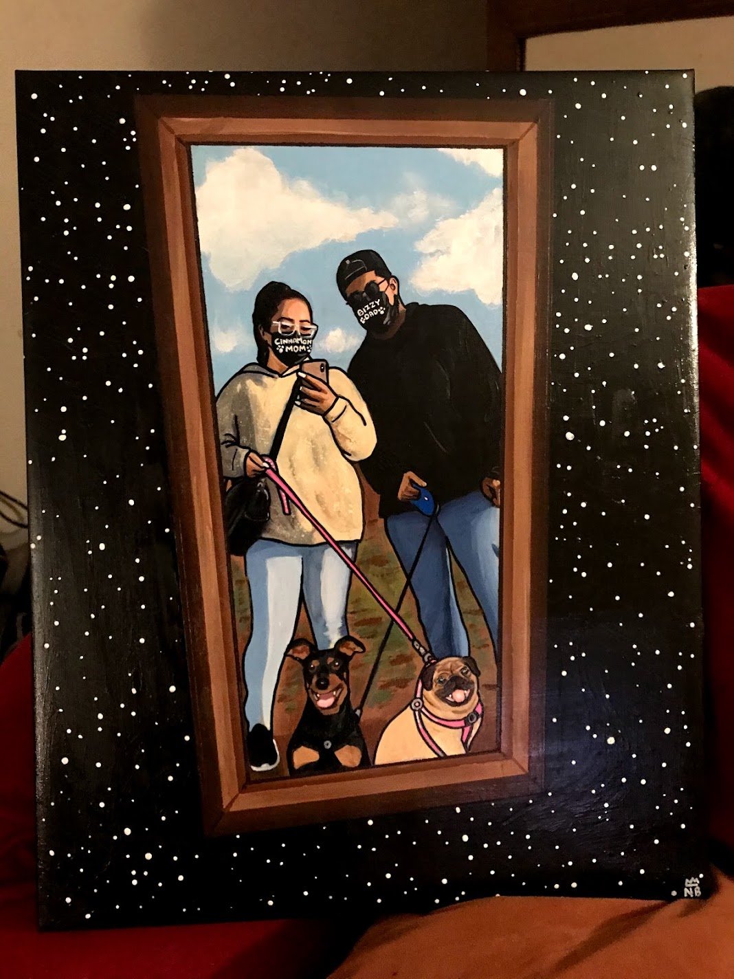 Commissioned painting of two people and their two dogs inside a painted frame against a starry black background