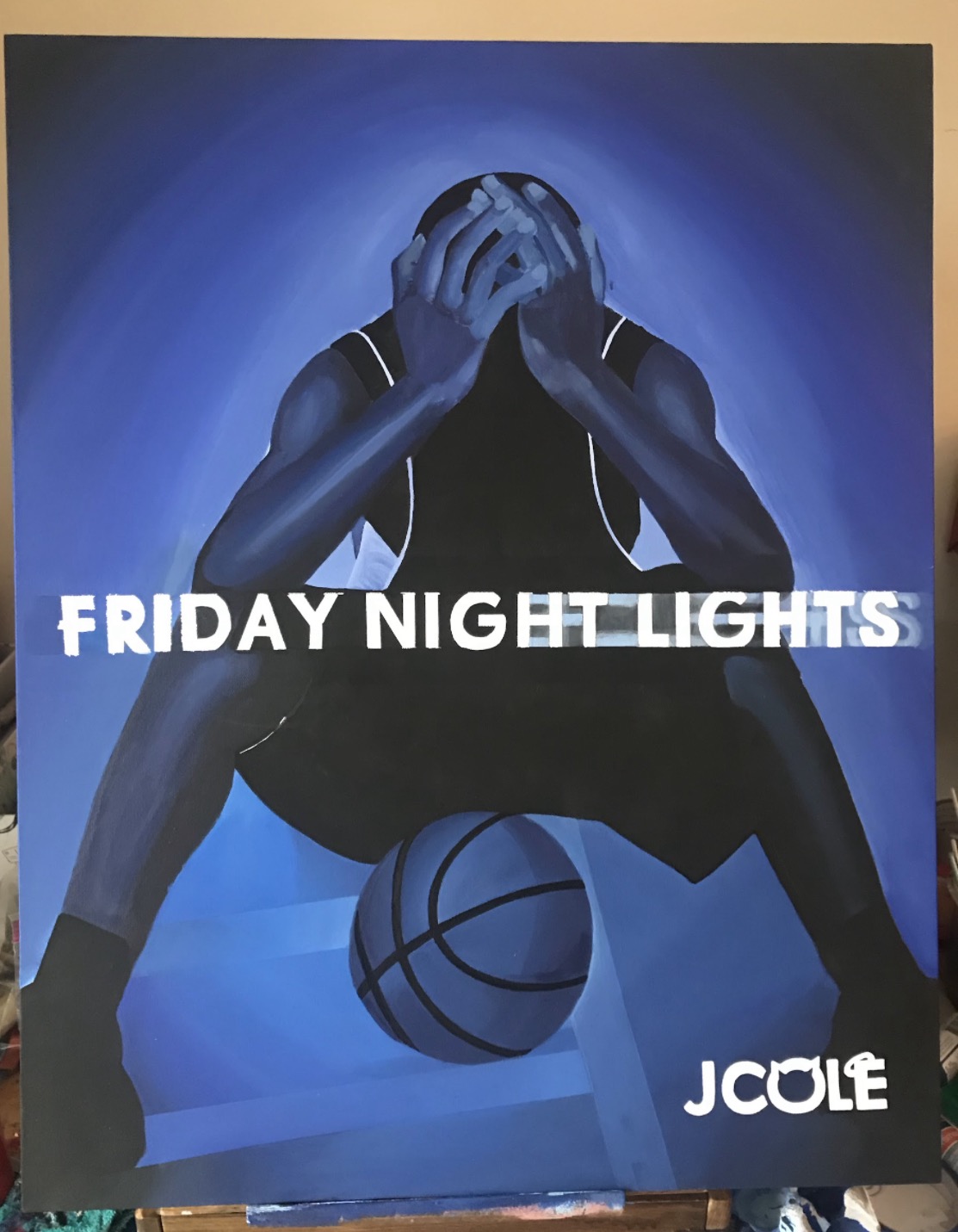 Blue painting of a seated basketball player with Friday Night Lights and J. Cole lettering
