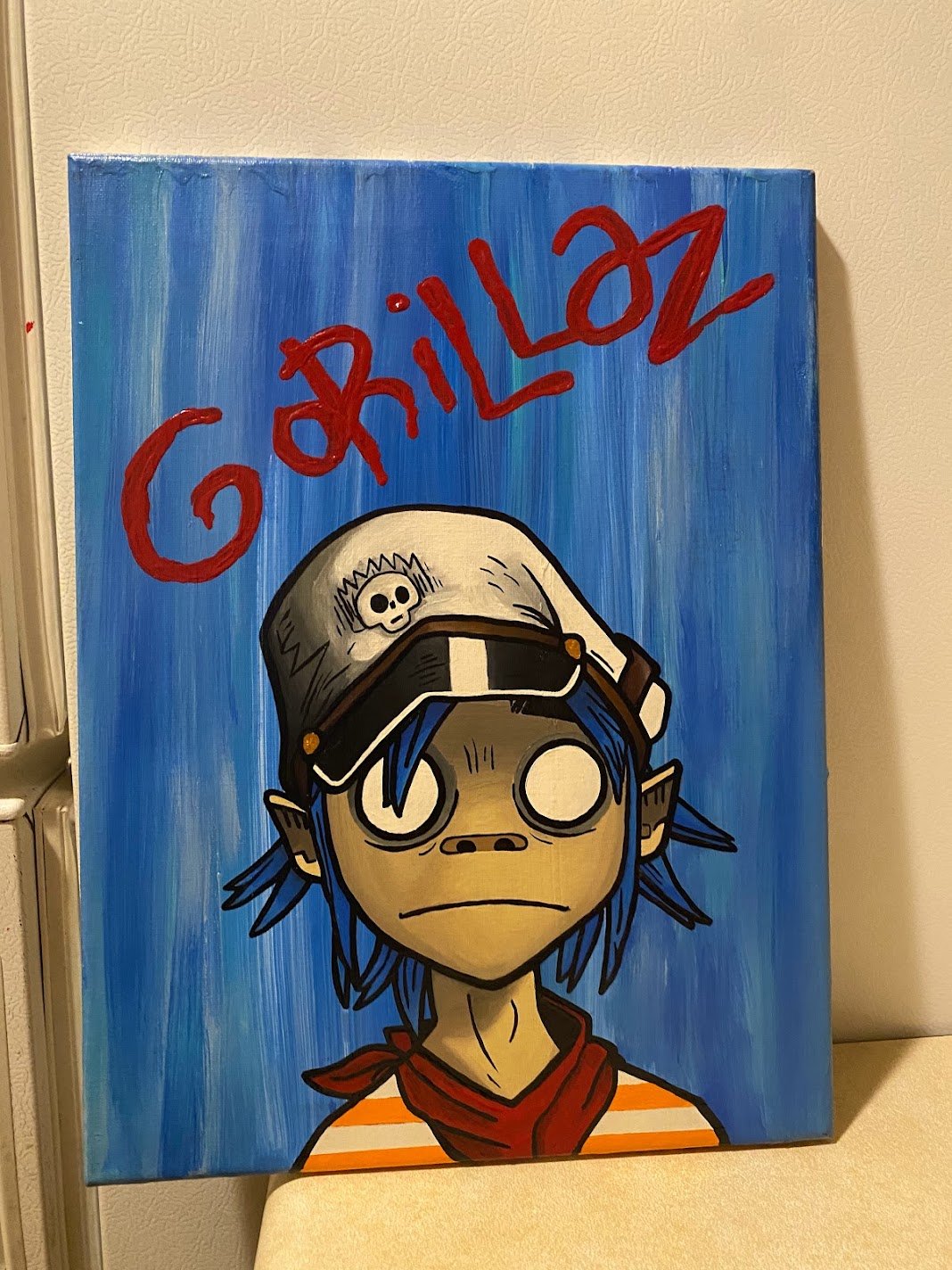 Blue Gorillaz-inspired character painting with red lettering