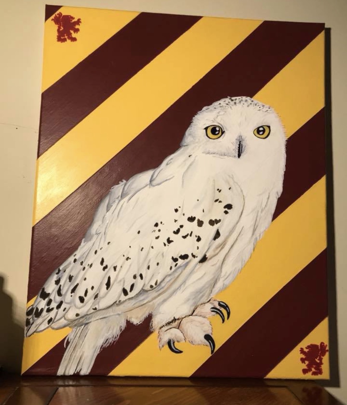 Hedwig owl painting by Nika B against burgundy and gold diagonal stripes