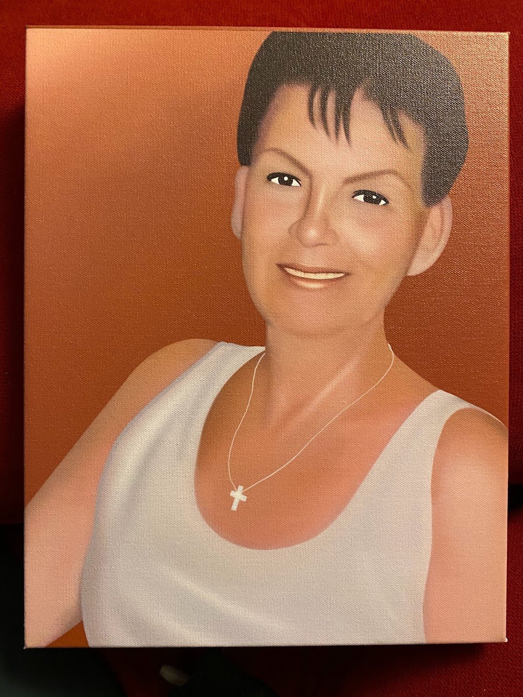 Commissioned portrait of a woman in a white top against a warm amber background