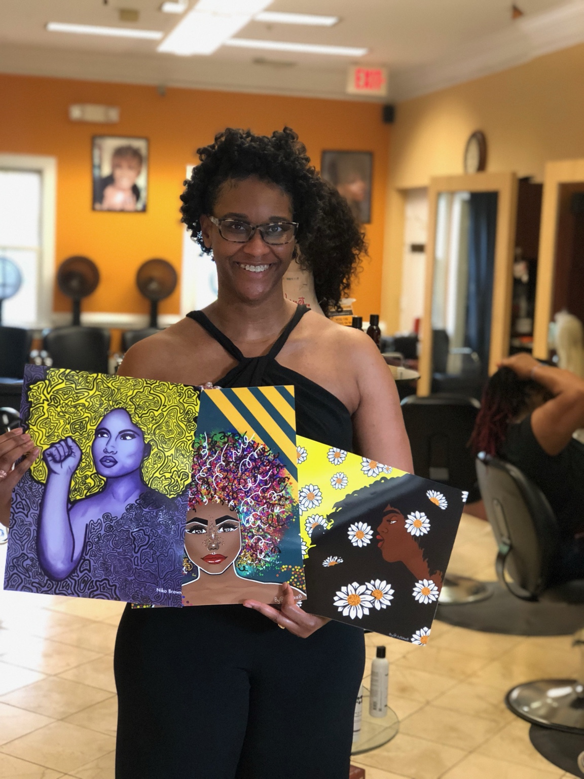 Customer holding three colorful art prints by Nika B